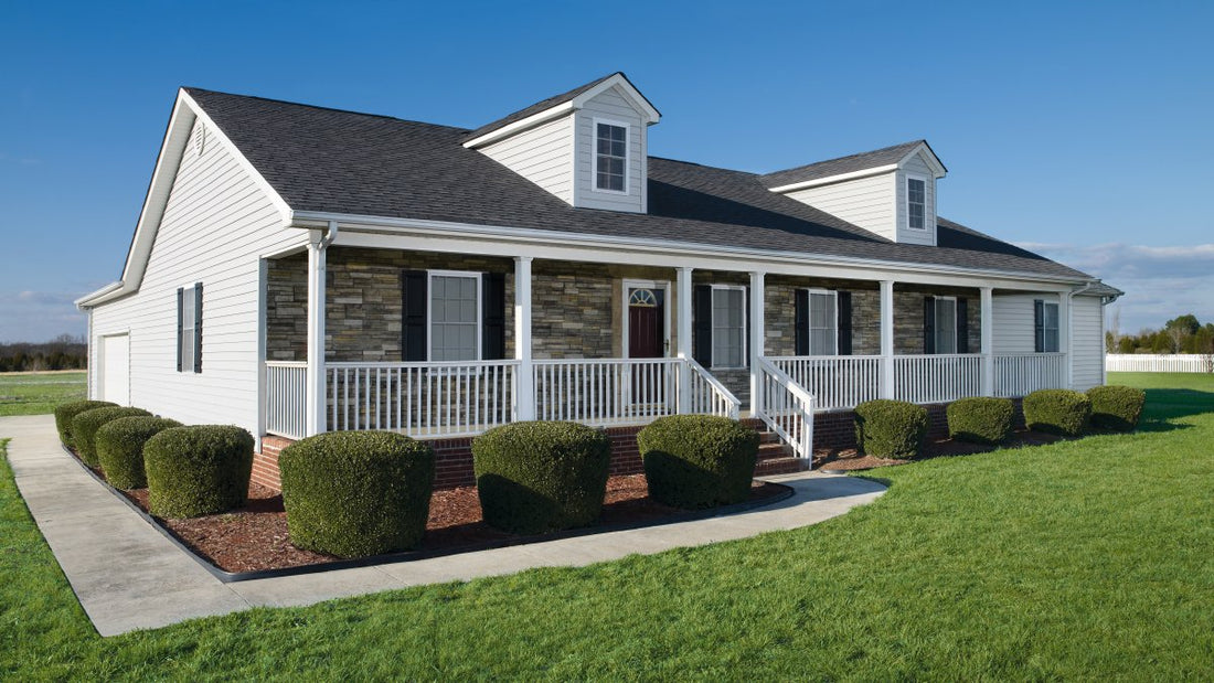 Stone porch columns on a white single-story home surrounded by lawn, featuring Versetta Sterling Ledgestone.